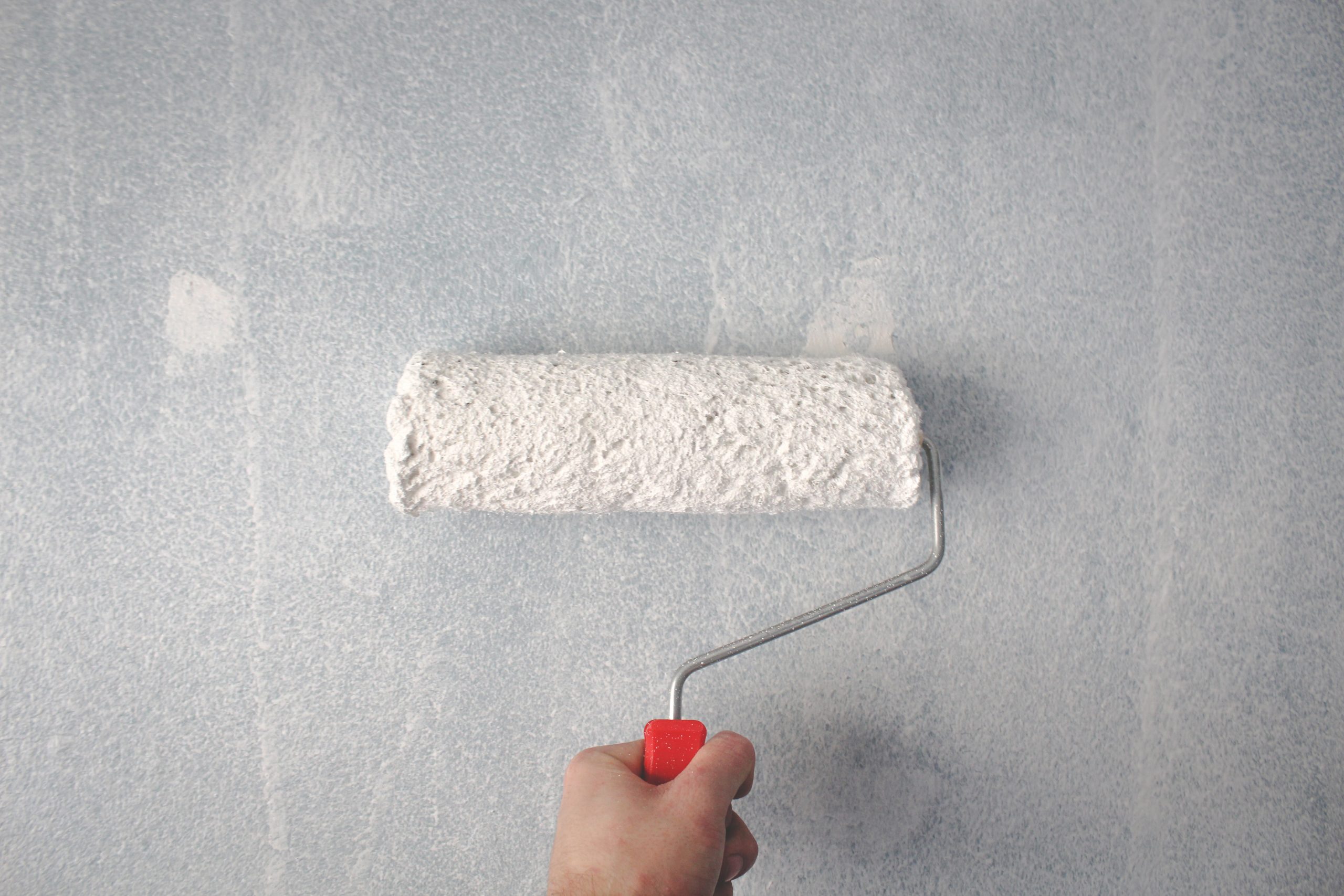 person-holding-paint-roller-on-wall-1669754